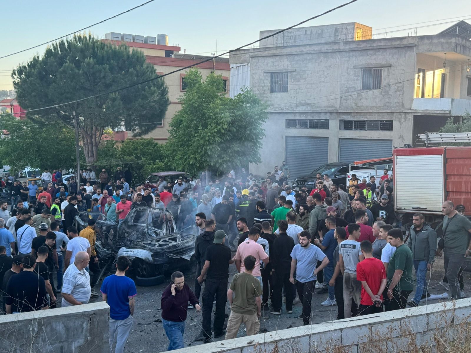 تجمع عدد من الاهالي بمحيط السيارة المستهدفة من قبل مسيرة اسرائيلية في النبطية. (سمير صباغ)